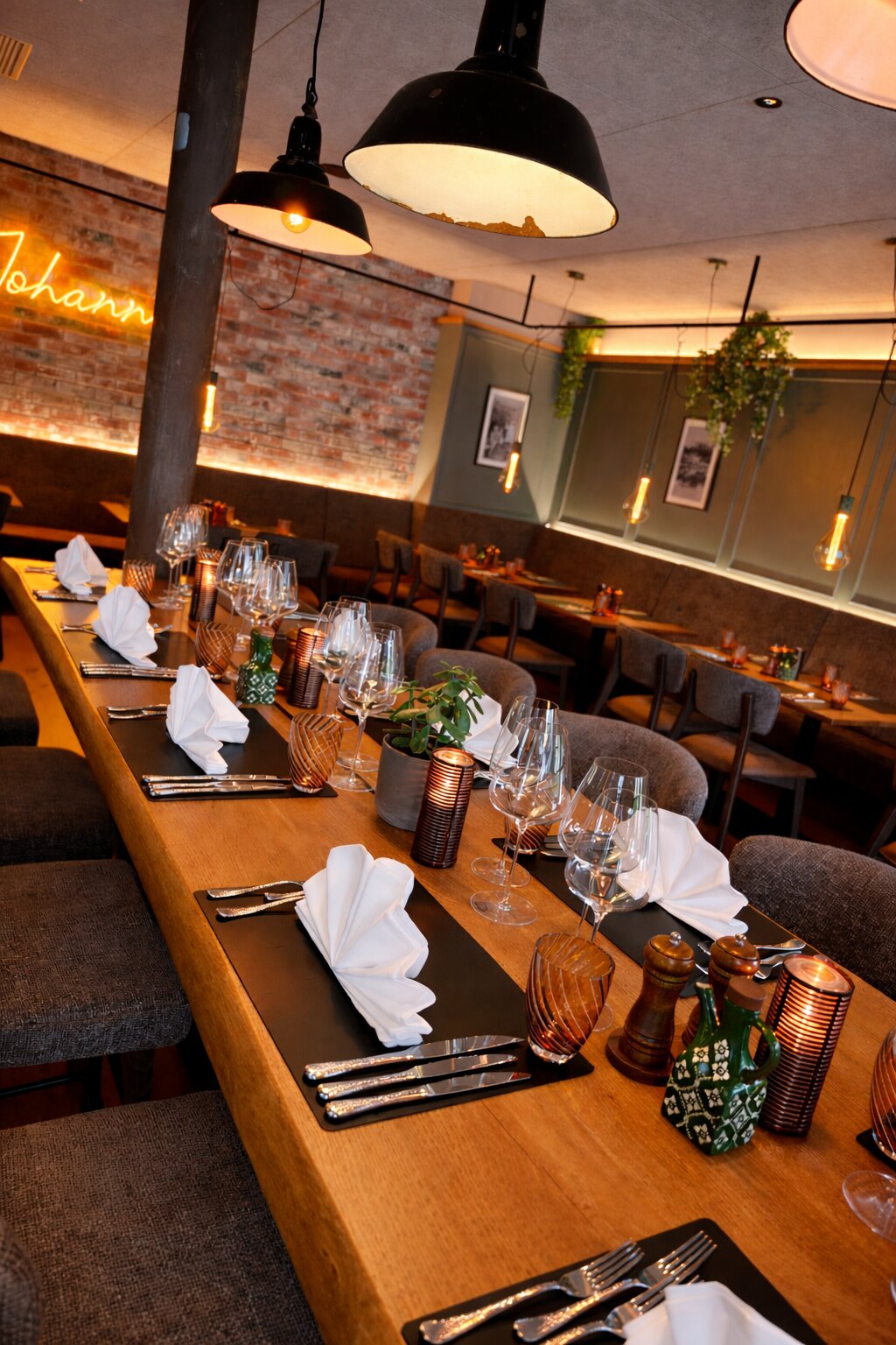 Chef’s Table – Die lange Tafel Die lange, festlich eingedeckte Tafel im Gastraum des Johann’s